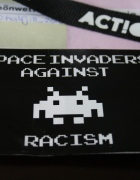 Auf dem Bild: Ein republica-Ausweis, der mit einem Aufkleber verziert ist. Auf dem Aufkleber steht "Space invaders against racism".